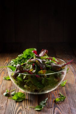 Taze salata ile karışık yeşillik (roka, pazı) ahşap rustik ahşap masa üstü. Düşük anahtar organik gıda