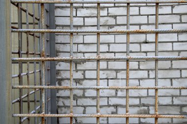 Kirli beyaz tuğla duvarın yanında demir kafes