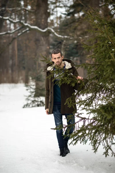 El hombre esconderse detrás de un árbol en el invierno — Foto de Stock