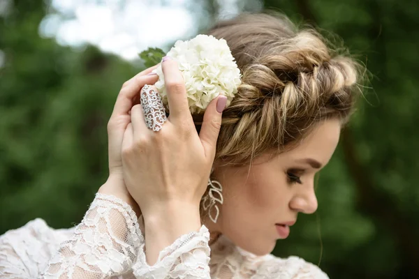 La joven endereza la flor en la cabeza — Foto de Stock