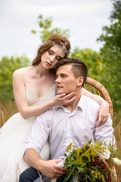 O casal nas orelhas de trigo na floresta. A noiva e o noivo nas orelhas de trigo no Parque . — Fotografia de Stock