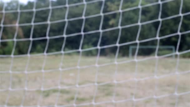 Rete da football. griglia di calcio. vista attraverso la rete da calcio sul cancello opposto. campo di calcio rurale — Video Stock