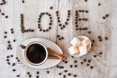 Kahve taneleri, Lokum ve tarçın ile ahşap arka plan üzerine yapışır. kahve sevdiğini başlık.