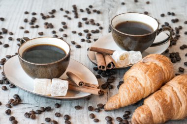 Kahve taneleri, kruvasan, Lokum ve tarçın ile ahşap arka plan üzerinde sopa