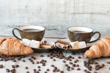 Kahve taneleri, kruvasan, Lokum ve tarçın ile ahşap arka plan üzerinde sopa