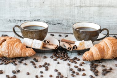 Kahve taneleri, kruvasan, Lokum ve tarçın ile ahşap arka plan üzerinde sopa