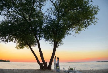 gün batımında sahilde genç Çift