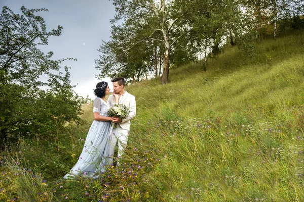 Casal jovem no amor ao ar livre. Noiva elegante e noivo posando juntos ao ar livre em um dia de casamento. noiva e noivo no Parque. jovem casal na floresta. jovem casal na grama. casal caminhando — Fotografia de Stock