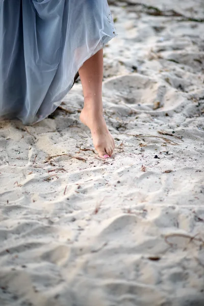 Le pied d'une belle fille sur le sable. jeune fille marche sur la plage — Photo