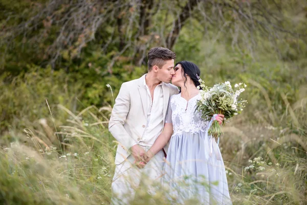 Casal jovem no amor ao ar livre. Noiva elegante e noivo posando juntos ao ar livre em um dia de casamento. noiva e noivo no Parque. jovem casal na floresta. jovem casal na grama. casal caminhando — Fotografia de Stock