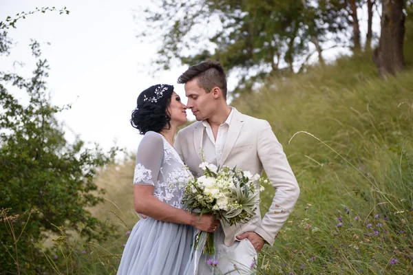 Casal jovem no amor ao ar livre. Noiva elegante e noivo posando juntos ao ar livre em um dia de casamento. noiva e noivo no Parque. jovem casal na floresta. jovem casal na grama. casal caminhando — Fotografia de Stock