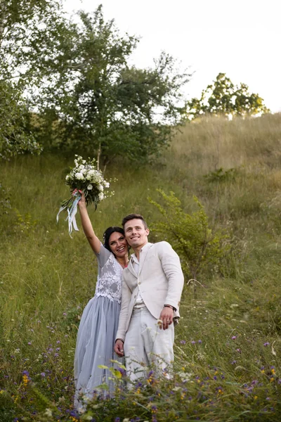 Casal jovem no amor ao ar livre. Noiva elegante e noivo posando juntos ao ar livre em um dia de casamento. noiva e noivo no Parque. jovem casal na floresta. jovem casal na grama. casal caminhando — Fotografia de Stock