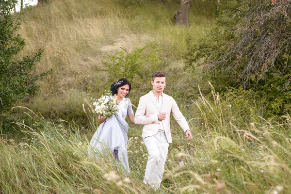 Mladý pár v lásce venkovní. Elegantní nevěstu a ženicha pózuje spolu venku na svatební den. Nevěsta a ženich v parku. mladý pár v lese. mladý pár v trávě. pár — Stock fotografie