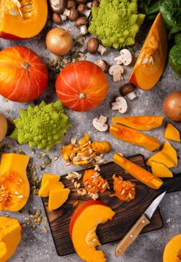 Vegan menü konsepti. Organik balkabağı sebzeleri ve masada kesme tahtası olan yeşiller..