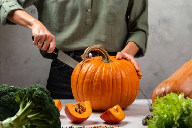 Mutfakta balkabağı kesen kadın elleri. Yakın plan..