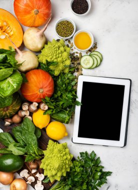 Sağlıklı yemek pişirmek için gerekli malzemeleri içeren tablet bilgisayar.