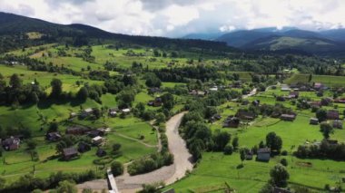 Nehir ve ahşap evlerle Karpat Dağları havadan manzaralı.