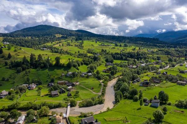 Montañas pueblo paisaje con río y hermosas casas de madera vintage vista aérea. — Foto de Stock