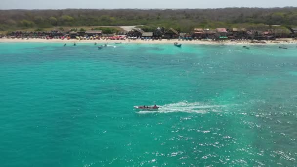 Un bateau de plaisance emmène les touristes faire une excursion le long d'une plage tropicale de sable vue aérienne. — Video