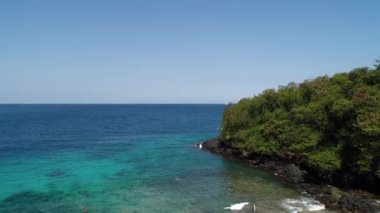 Ada havası manzaralı gök mavisi suyu olan güzel bir sahil.