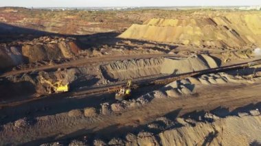 Gün batımında hava manzaralı bir taş ocağında ağır madencilik makineleri..
