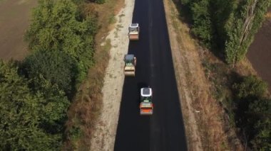Yol silindirleri yeni asfalt otoyol hava manzarasını inşa ediyor.