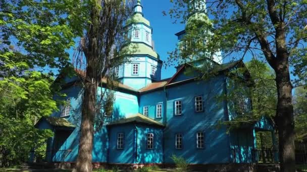 Veduta aerea in prima persona della chiesa in legno circondata da alti alberi secolari. — Video Stock