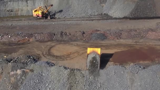 Caminhão amarelo grande derrama minério de metal do corpo perto de uma pedreira vista panorâmica superior aérea — Vídeo de Stock