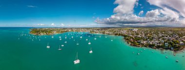 Büyük Baie Mauritius 'un, demirli yelkenli tekneleriyle göldeki kıyı bölgelerini ve dalgalı öğleden sonra bulutlarını gösteren hava manzarası. Yüksek kalite fotoğraf
