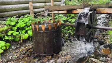 Ahşap dişli varilleri ve basit yerçekimi tarafından yönetilen akıntıyla sabit akımda çalışan el yapımı su gücü aparatı..