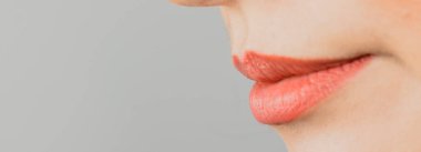 Tarafsız bir arkaplanda yumuşak pembe renkli kadın dudakları.