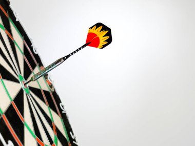 Dart tahtası hedefine saplanmış siyah ve beyaz tasarımı olan dartın yakın çekimi