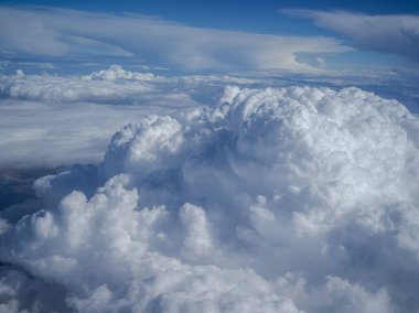 Mavi gökyüzüne karşı parlak beyaz kabarık bulutların havadan görünüşü