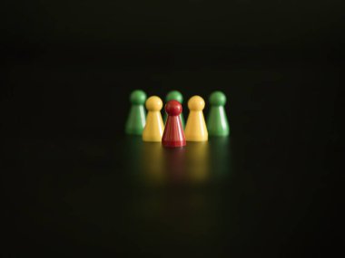 Koyu bir yüzeye dizilmiş beş renkli oyun parçası.