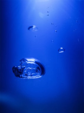 Su kabarcıkları derin mavi bir okyanusta yüzüyor..