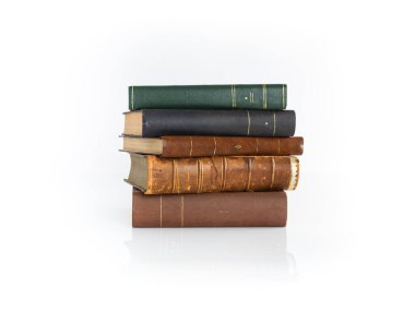 Beyaz bir yüzeyde duran antika kitap yığını..