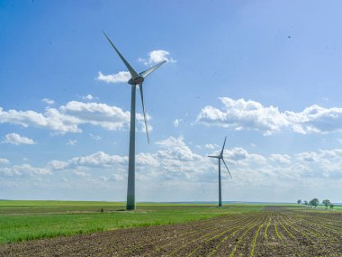 Açık alanda duran iki rüzgar türbini..