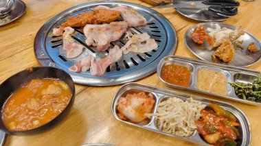 Kore barbekü ızgarası, dilimlenmiş domuz eti, biftek ve sebzeli sıcak tavada, Kore barbekü yemeği konsepti.