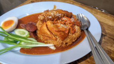 Pirinçli kırmızı domuz eti, haşlanmış yumurta ve dilimlenmiş salatalık.