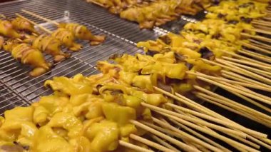 Taze terbiye edilmiş mürekkep balığı şişleri, baharatlı deniz ürünleri soslu Tayland sokak ızgarası.