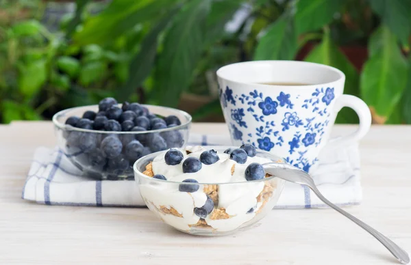 Fitness wheat muesli with yogurt, blackberry and tea