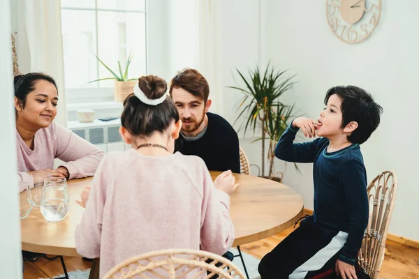 Mixed family playing with board game together at the table