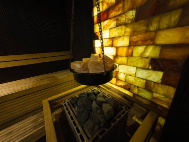 Işıldayan Himalaya tuz bloğu duvarı ve spa rahatlaması için ısıtıcısı olan modern bir saunanın içi..