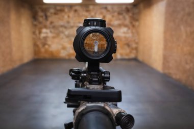 Prizmatik bir manzarayla birinci şahıs görüntüsü. Aydınlatılmış parçacık tam olarak kapalı bir atış poligonundaki bir hedefe odaklanmış..