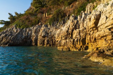 Saint-Jean-Cap-Ferrat glowing with golden hour light, meeting the beautiful turquoise Mediterranean Sea on the French Riviera.