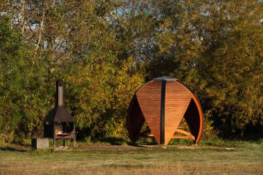 Modern küresel ahşap bir çardak ve Estonya 'da bir parkta halka açık piknik yerinde ızgara..