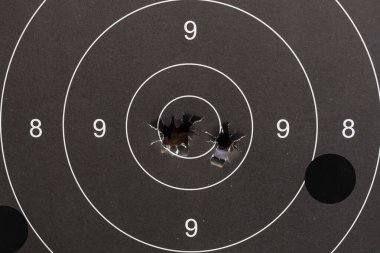 Kullanılmış siyah kâğıt atış hedefi mükemmel bir isabet sağlıyor. 9-ring ve tam isabet arasında birden fazla atış var..