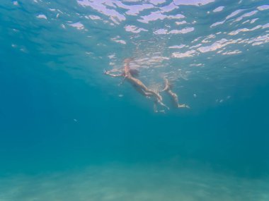 Fransa 'nın Nice kentindeki uçsuz bucaksız mavi Akdeniz' de yüzen iki insanın sualtı görüntüsü..