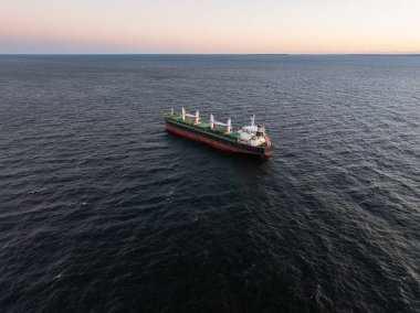 Büyük bir kargo gemisinin uçsuz bucaksız Baltık Denizi, Estonya 'da huzurlu bir günbatımında yelken açması..