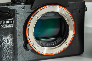 Görüntü sensörü ve metal lens monte halkasını ortaya çıkaran profesyonel siyah aynasız dijital kamera gövdesinin yakın plan detayları.